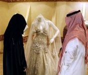 A Saudi couple prepare for their wedding. Admiring a bridal outfit. Some Muslim nations seem to have no culture of their own and borrow from others.