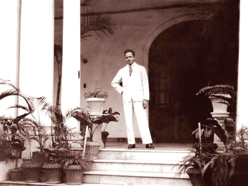 Hussein standing in the Loggia facing lawn and sunken garden
